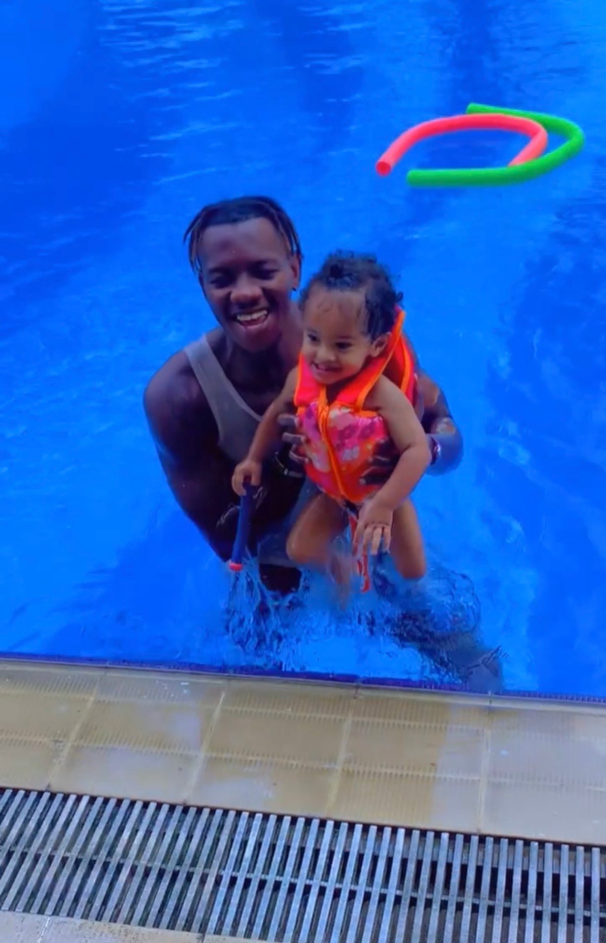 Moniteur avec un bébé souriant dans la piscine
