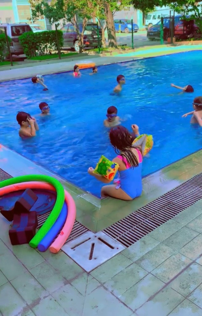 Jeune fille en brassards et enfants en séance collective