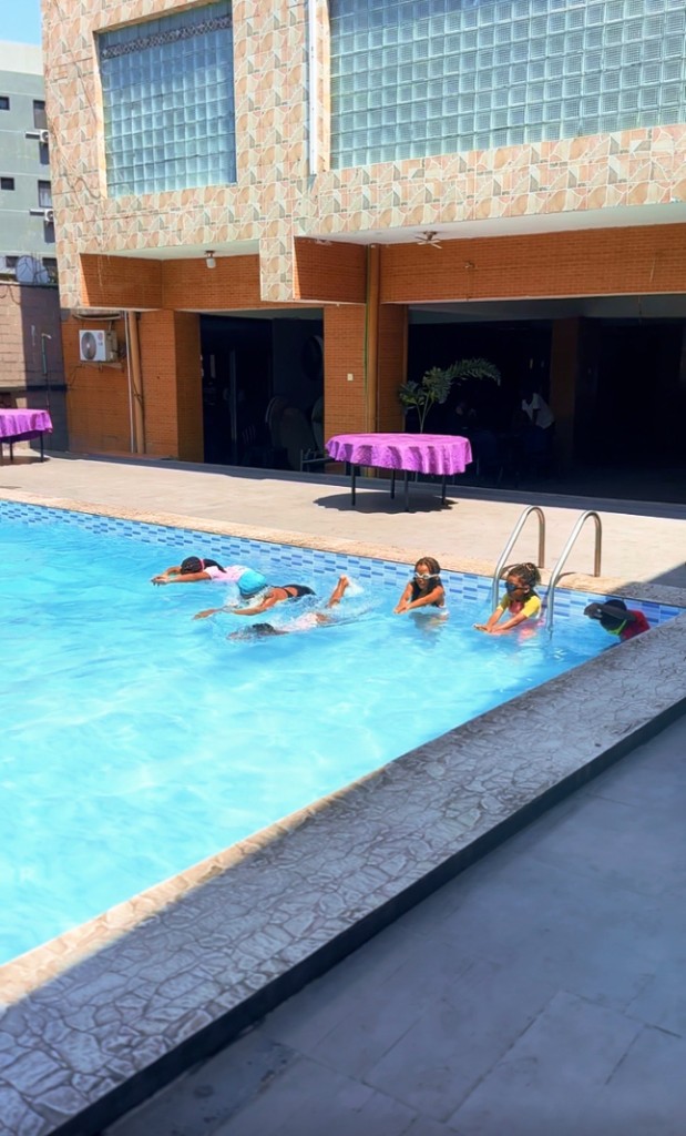 Groupe mixte d'enfants en apprentissage dans la piscine